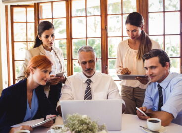 Business people discussing over laptop at table in restaurant