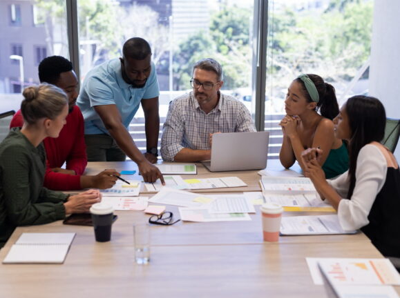 Biracial female and male advisors discussing over boardroom during meeting at modern workplace. unaltered, business, teamwork and modern office concept.