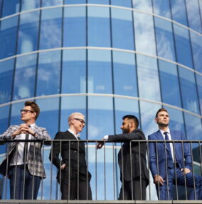 Group of young business people standing in the city with modern skyscraper in the background